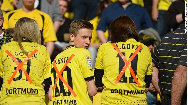 Dortmund fans wear replica jerseys of midfielder Mario Goetze with a X though them following his controversial transfer to bitter Bundesliga rivals Bayern Munich.